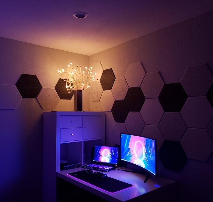 Another reviewer’s desk, with white, gray, and black acoustic panels arranged decoratively around it on the wall.