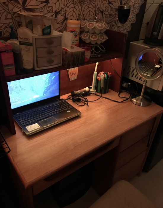 A desk illuminated by an LED light that brightens a computer.