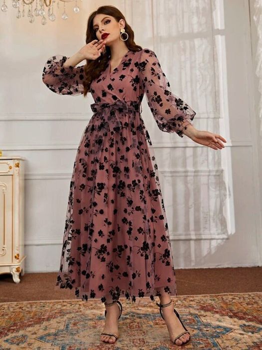 Model wearing an ankle-length, long-sleeve dress with a delicate floral overlay