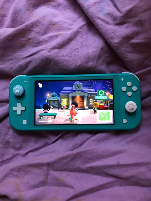 Another reviewer’s Nintendo Switch, this time with two paw print joystick caps in place, showcasing how these adorable accessories can personalize and enhance the overall gaming experience.