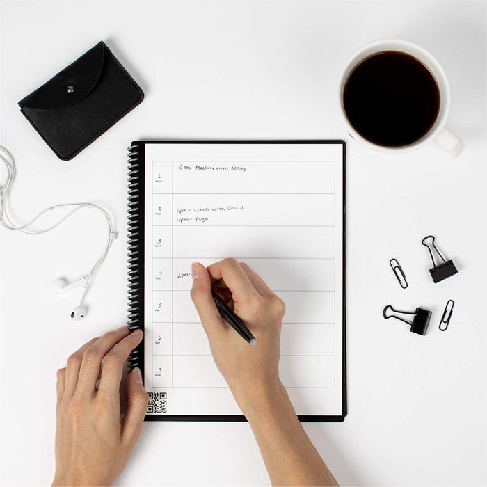 A model writes in the planner section of a Rocket notebook.