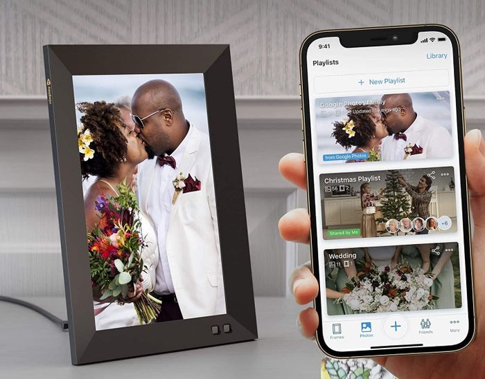 The digital picture frame with a phone displaying the app, where albums can be created and shared.