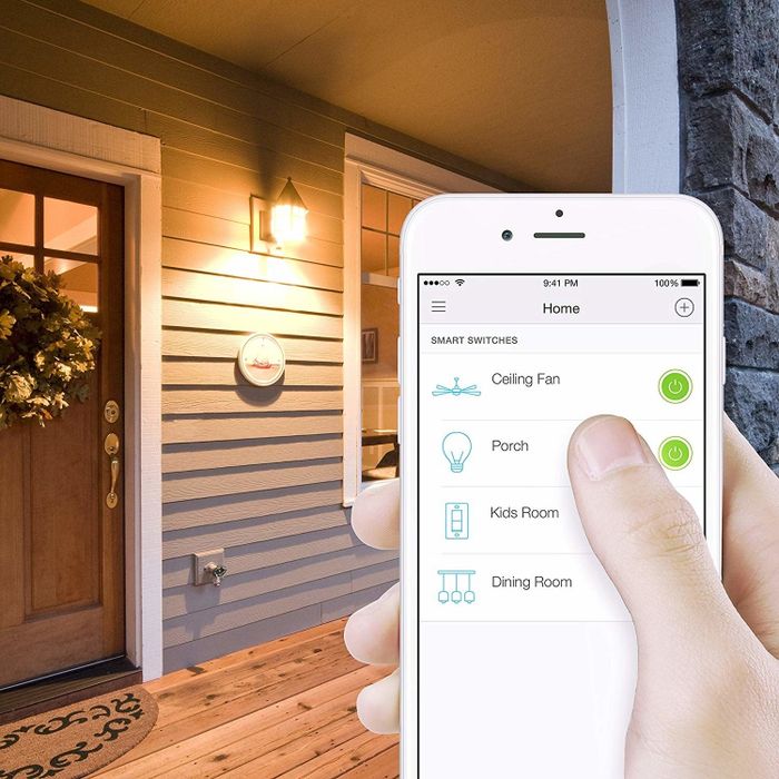 A person using the Kasa Smart Light Switch app to turn off the lights remotely.