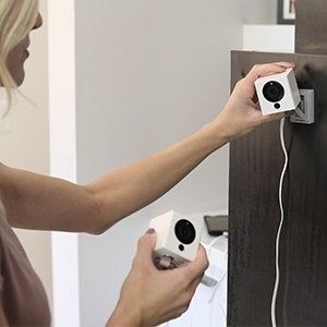 A person setting up the Wyze smart camera in their home.