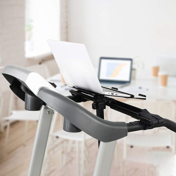 A laptop securely fastened to an attachment on a treadmill.