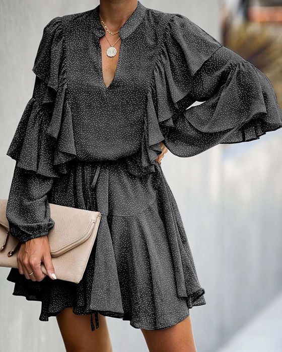 Model wearing a gray dress with playful ruffles.