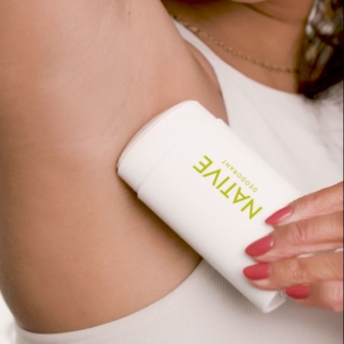 Model applying the stick deodorant to their underarm
