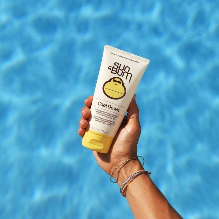 A model is seen holding the lotion above a pool of water.