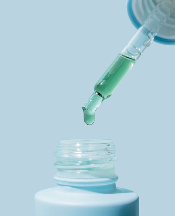 A dropper filled with the signature blue acne oil, ready for use.