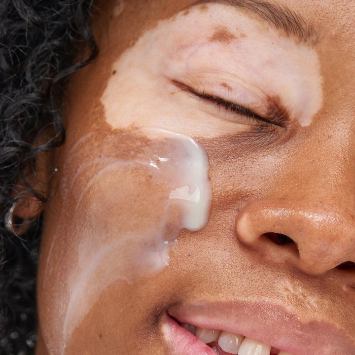 a model applying the serum to their cheek