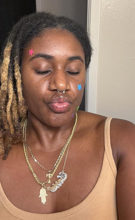 A reviewer wearing the star-shaped pimple patches, adding a touch of fun to their skincare routine.