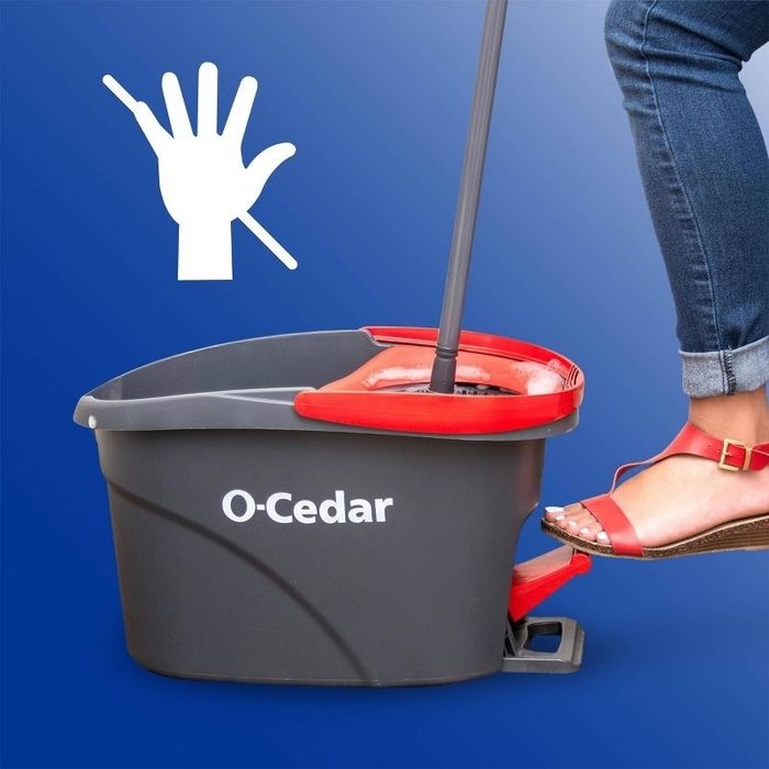 A foot pressing down on a spinning pedal to operate a mop bucket.