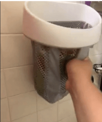 A reviewer effortlessly detaching the bag from its wall mount
