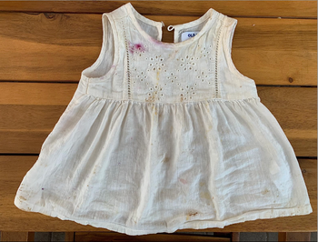 a white toddler dress covered in stains