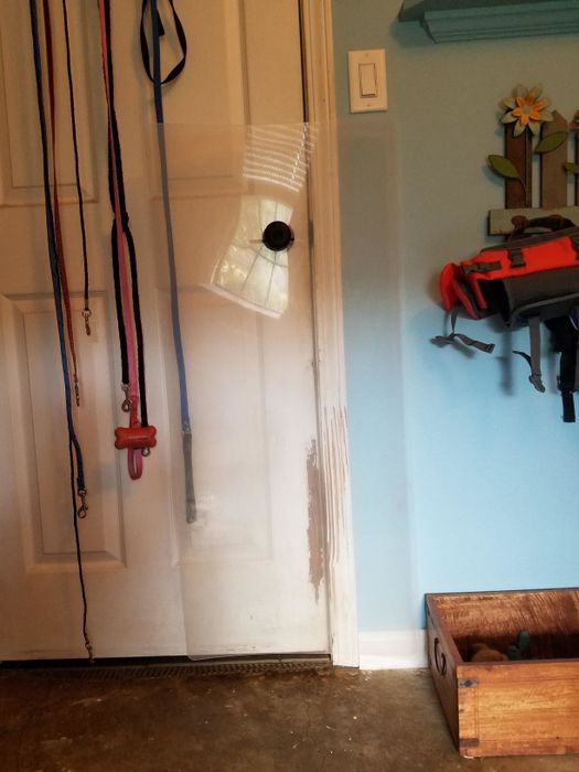 A reviewer photo showing the scratch guard attached to a door that already has some scratches near the bottom