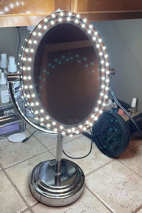 A reviewer's image of the oval mirror displayed in a bathroom.