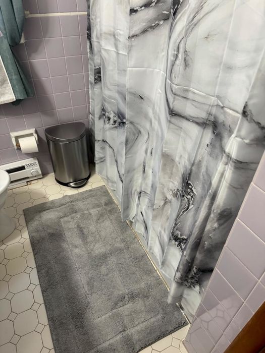 A review photo showcasing the light grey version of the bath mat.