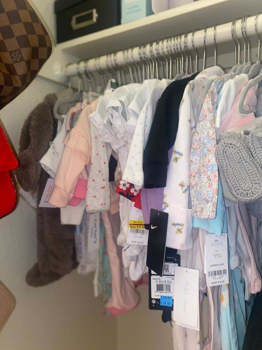 A rack displaying a variety of baby clothes with tags, ideal for shopping for infant apparel