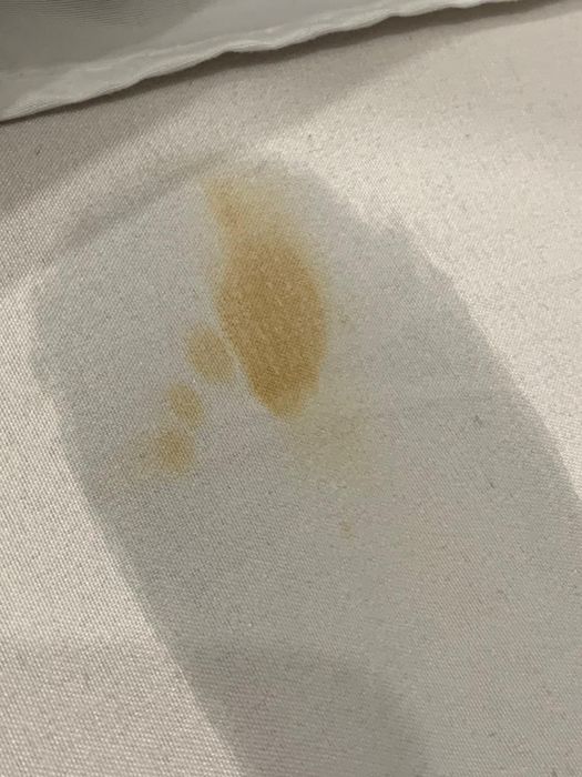 Reviewer's before photo displaying a yellow stain on white fabric
