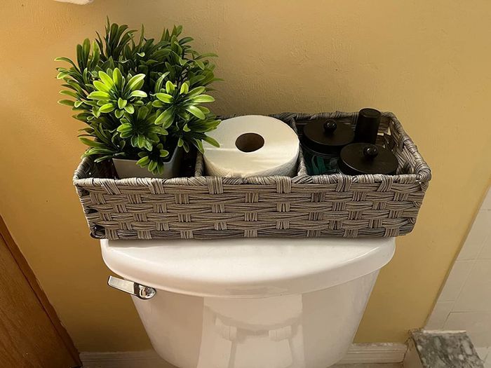 Reviewer image showing the basket placed on a toilet, demonstrating its functionality and style.