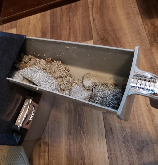 A photo from a reviewer showing the litter box tray pulled out, filled with clumps of litter.