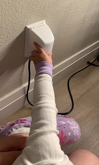 A child attempting to open the outlet box, as captured by a reviewer