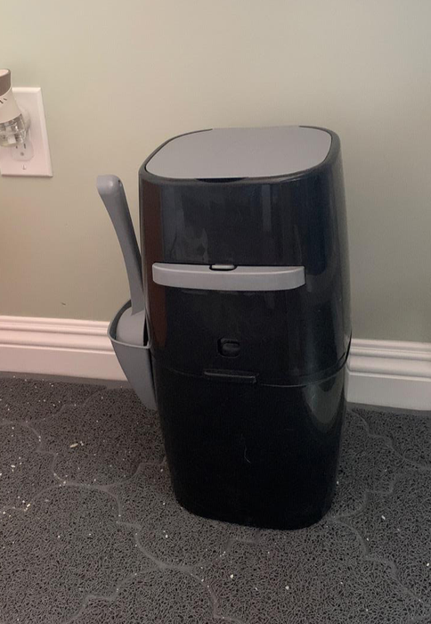The black and gray Litter Genie, featuring a side handle for easy storage of the scoop