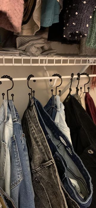 Another reviewer demonstrating the use of the hooks to hang their pants by the belt loops.