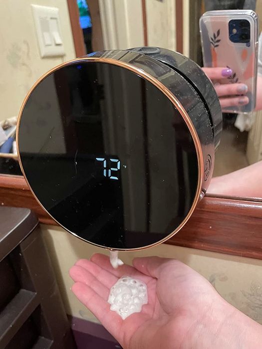 A reviewer has soap automatically dispensed into their hand