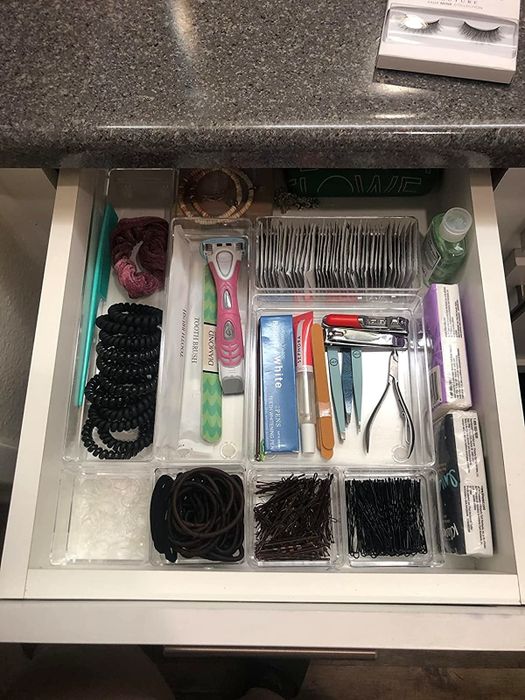 A neatly organized drawer containing various hair accessories and personal care items.