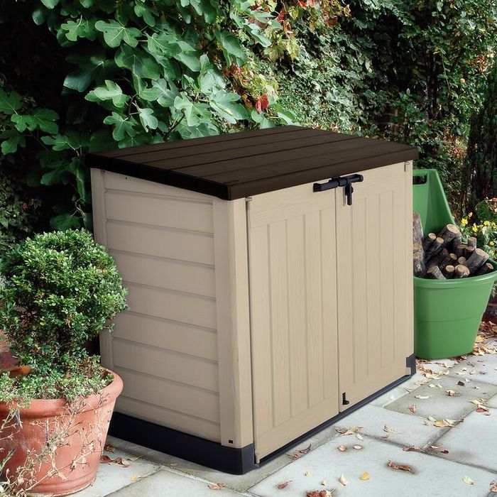 The garbage shed nestled in a backyard, keeping the bins safe from the elements.