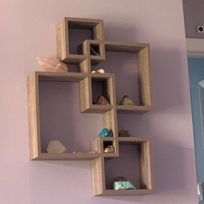 A photo from a reviewer showing the brown square accent shelves neatly arranged on a wall.