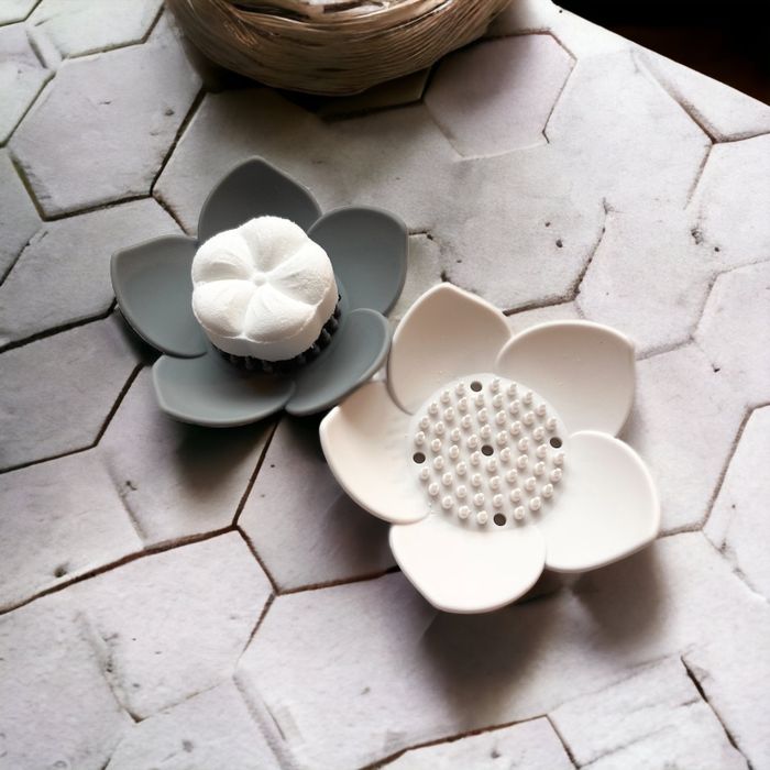 A shower steamer holder placed on the bathroom floor.