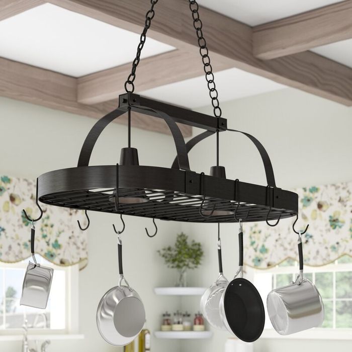 The pot rack hanging above, adorned with a collection of pots and pans, ready for use.