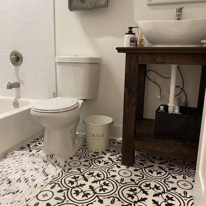 the countertop wastebasket placed beside a toilet