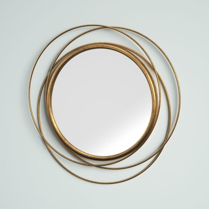 A round decorative mirror with a multi-ring bronze frame.