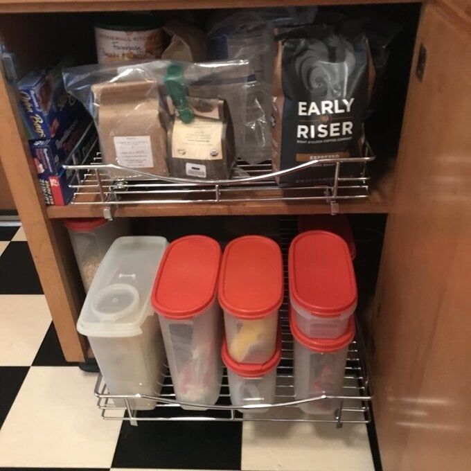 the same slide-out cabinet drawer containing plastic food storage containers inside a kitchen cabinet