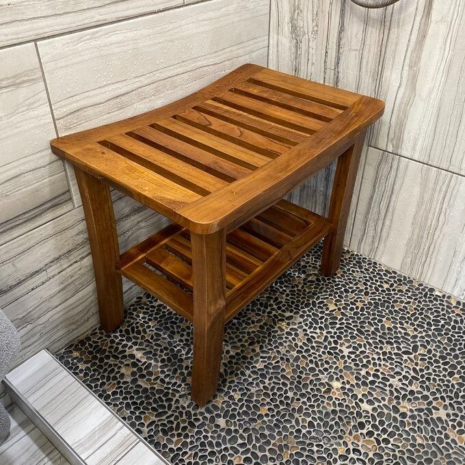 A wooden shower bench with a slatted design.
