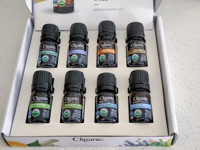 A box containing eight Cliganic essential oil bottles, each labeled with various scents such as peppermint and lavender.