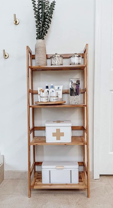 A bamboo shelf displaying various storage boxes and self-care products, offering an eco-friendly and efficient organization solution for your bathroom.