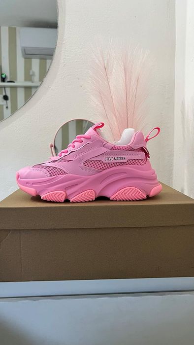 A reviewer shows off their pink Steve Madden sneakers.