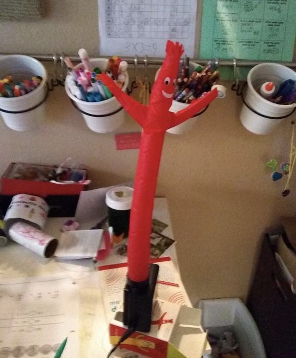 a reviewer's small red inflatable tube figure displayed on their desk