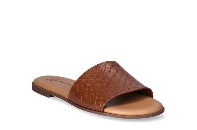 A brown, crocodile-embossed slide sandal shown on a white backdrop