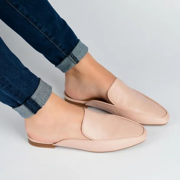 A model showcasing the blush-colored mules