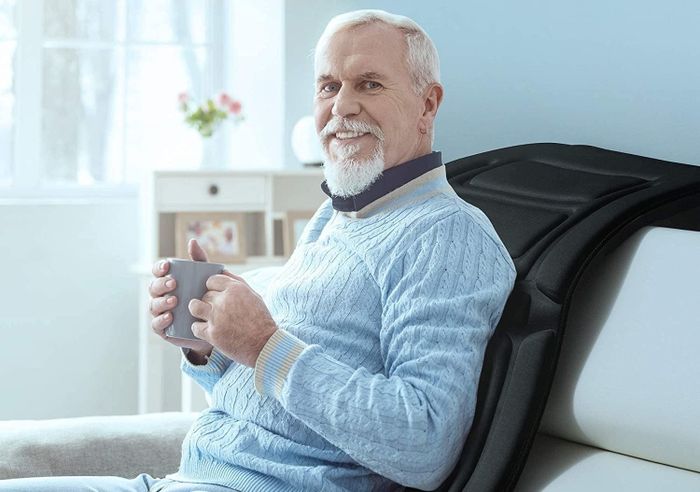Another model sitting up, using the mat against a couch while sipping coffee.