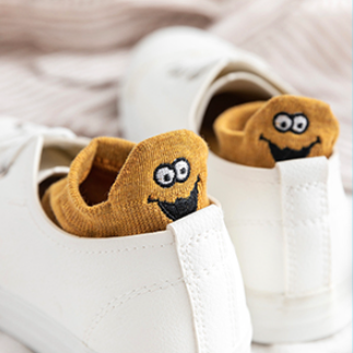 A pair of dark yellow expressive socks tucked inside a pair of shoes