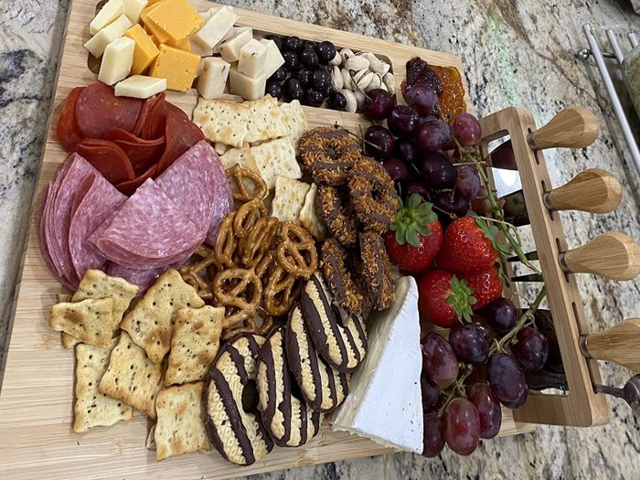 A charcuterie board filled with a delightful mix of meats, cheeses, fruits, nuts, and cookies.