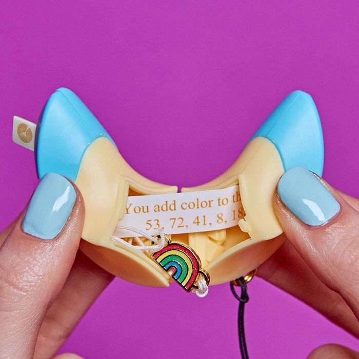 A person unwrapping one of the fortune cookies to reveal a hidden bracelet inside.