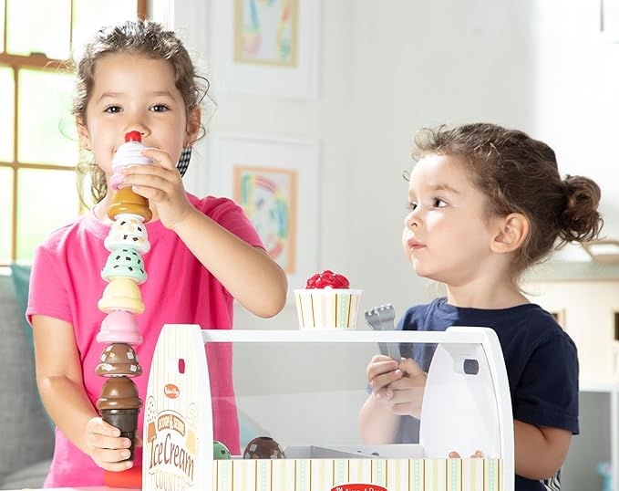 Two children playing together with the ice cream set.