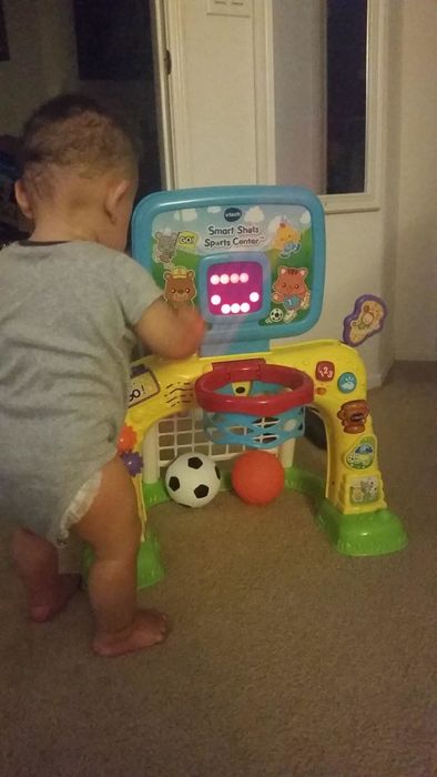 A reviewer’s child happily playing with the Vtech sports center, enjoying the interactive features.